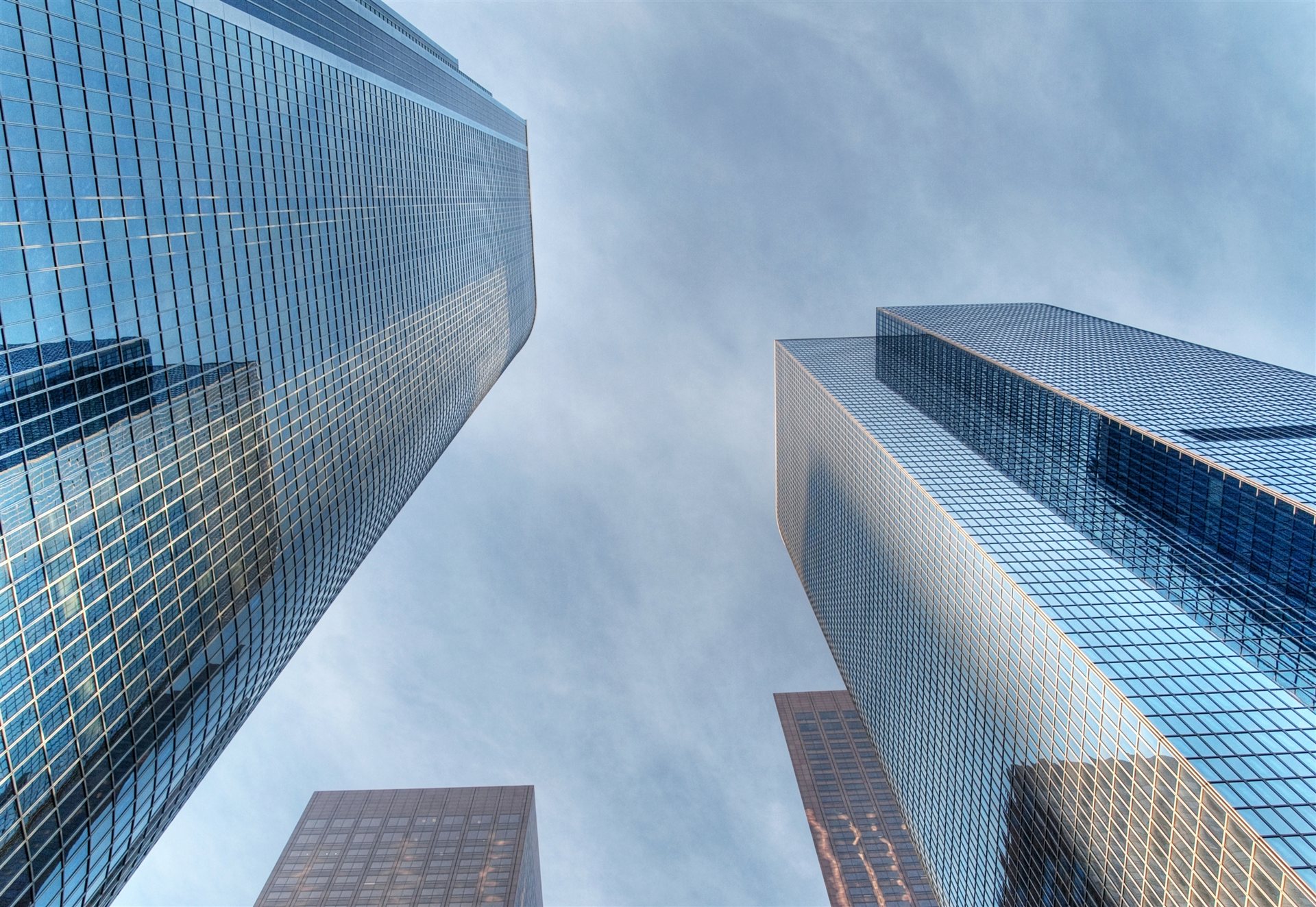 Glass skyscrapers rising against a cloudy sky